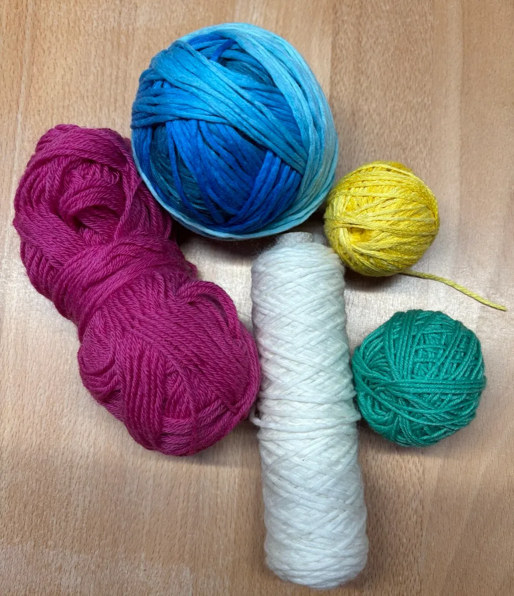 Bunte Wollknäuel auf Holztisch